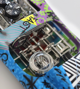 Close-up of a mechanical watch with colorful case design on a white background